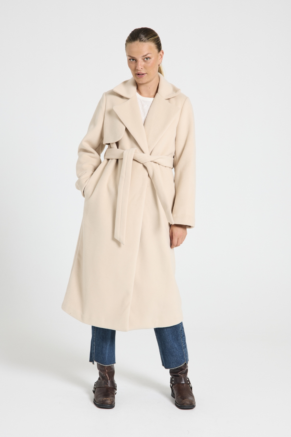 Jakke fra Freequent i myk ullblanding. Jakken er en klassisk omslagskåpe med belte i midjen, bredt jakkeslag, splitt bak samt bærestykke bak. Detaljer som kombineres for en trenchcoat-inspirert look.
90% polyester 10% ull