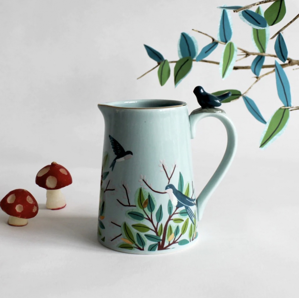 Materialer:  Porselen

Egenskaper:  En dekorativ melkekanne med en keramisk fugl plassert på håndtaket. Den er ferdig med et nydelig bladmønster på toppen av en myk blå glasur. Den har gulldetaljer for å legge til litt luksus. Det ville være en flott gave